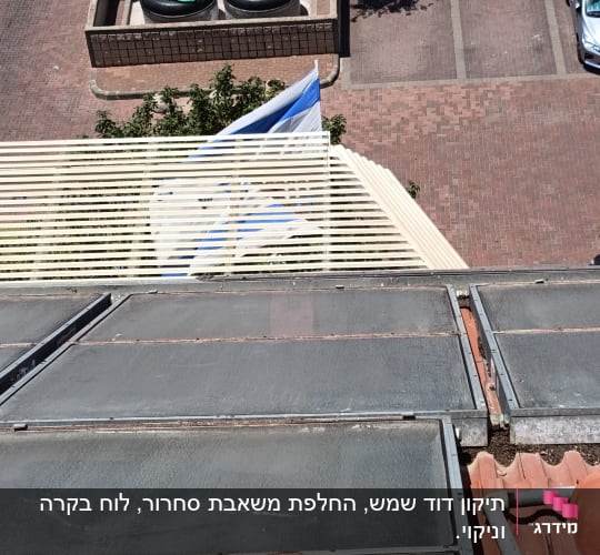קולטי שמש על גג עם דודי מים ברקע